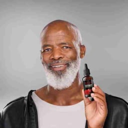 Man holding Sugar Defender drops bottle for daily blood sugar support and wellness routine
